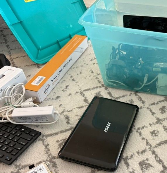 Two tubs of old computer parts and cables on the floor